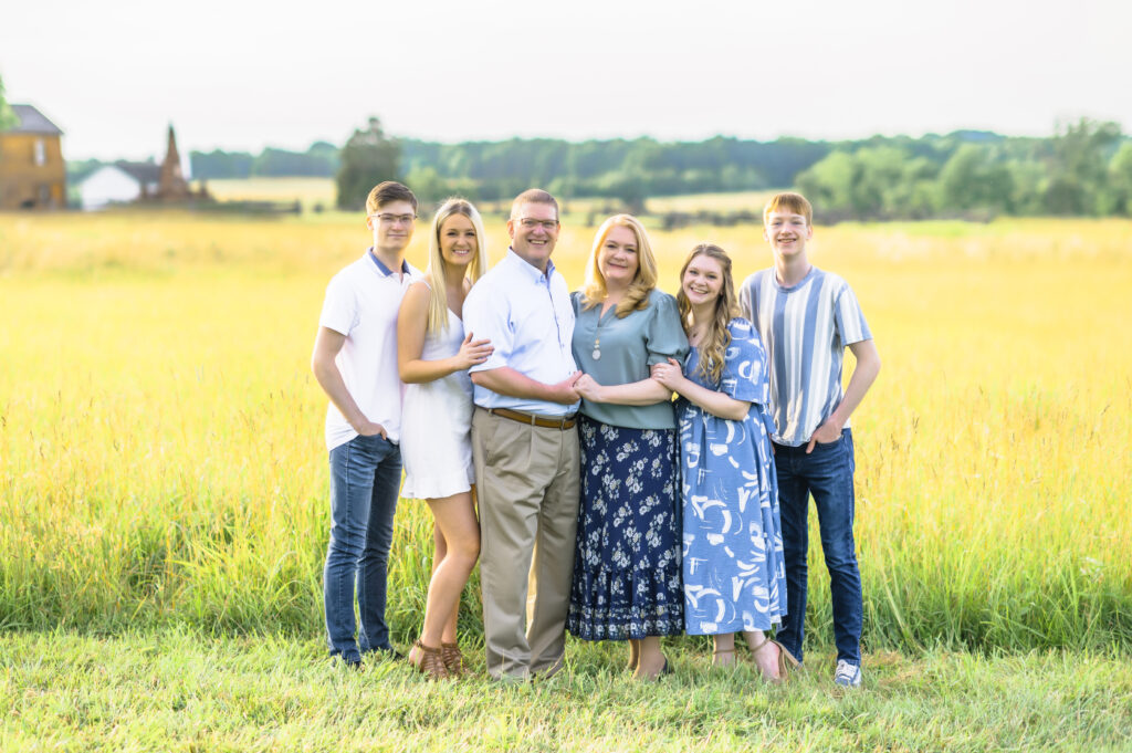 A family posing for a picture in the grass.